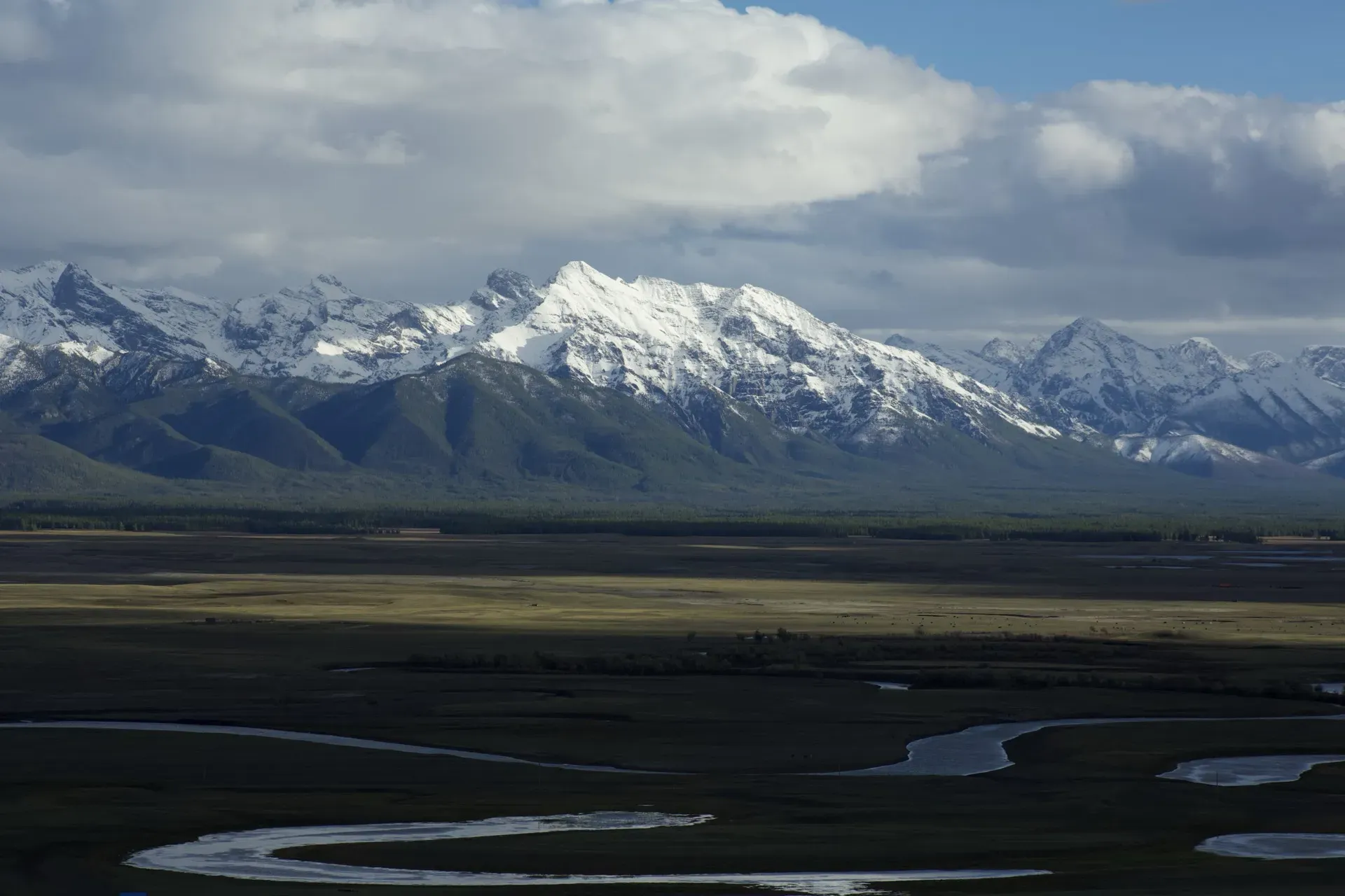 Snowy peaks over river and steppe